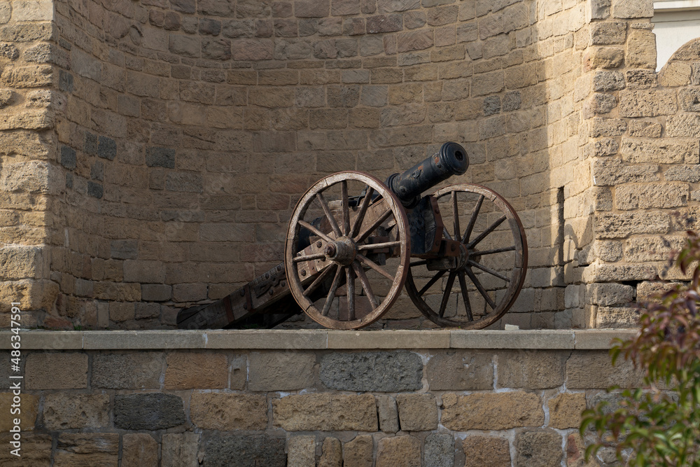 An ancient cannon against the background of the wall of the Old City. Historical center of Baku, Azerbaijan
