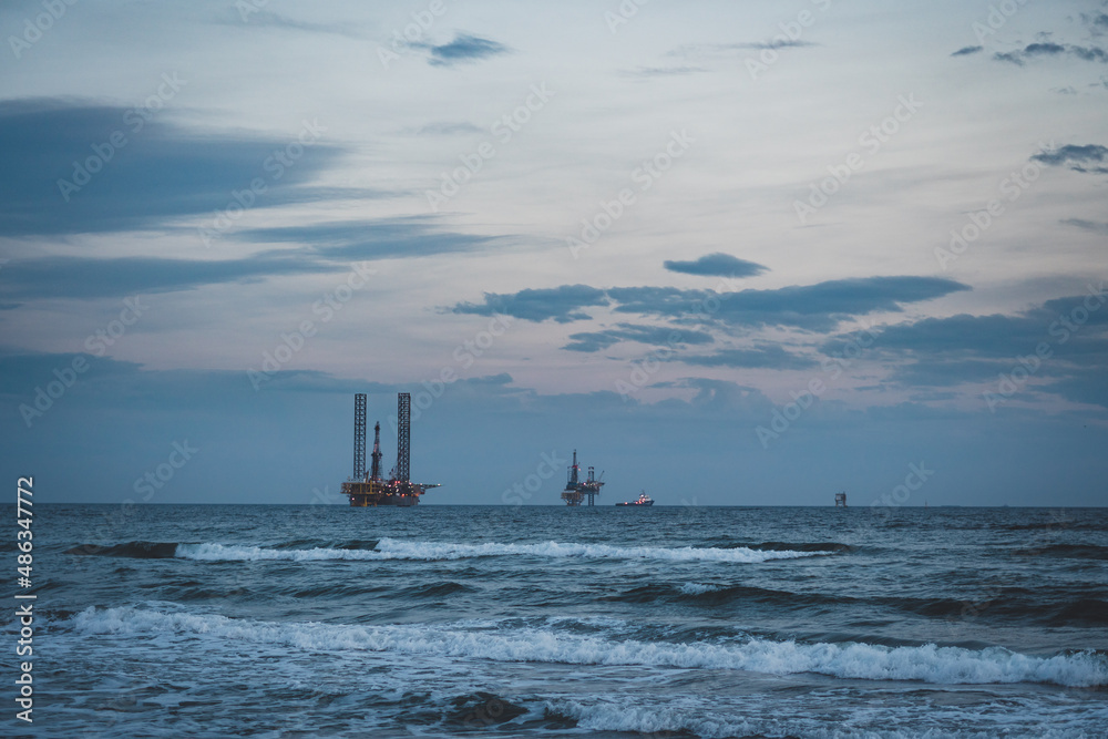 Gas and oil rig platforms on the horizon.