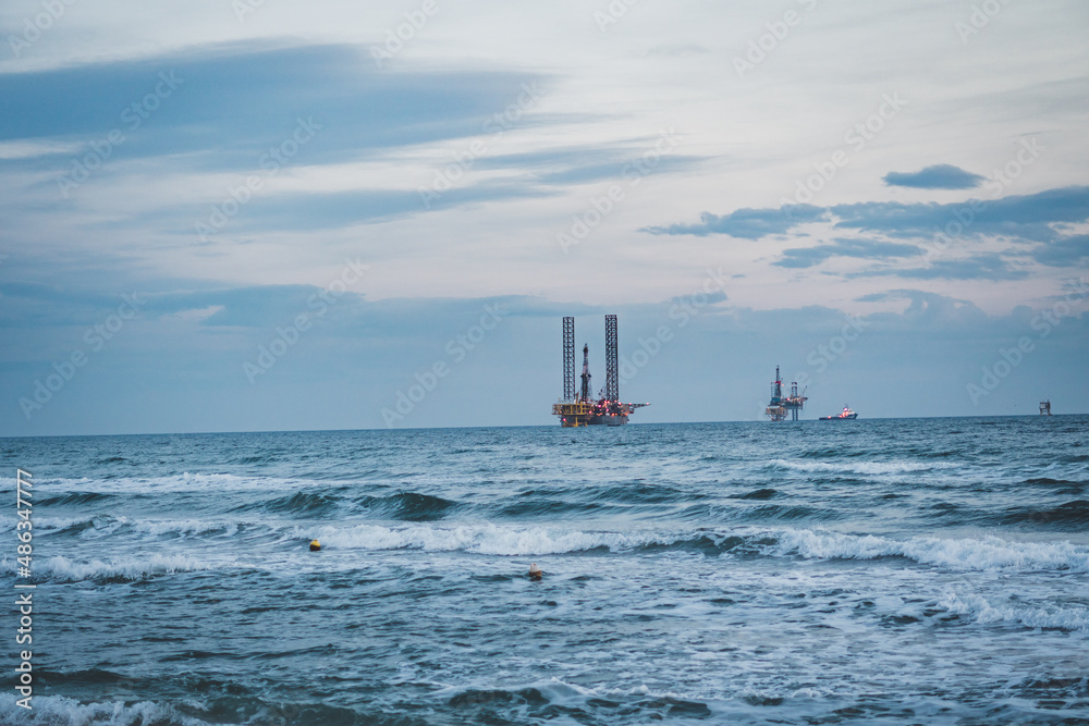 Gas and oil rig platforms on the horizon.
