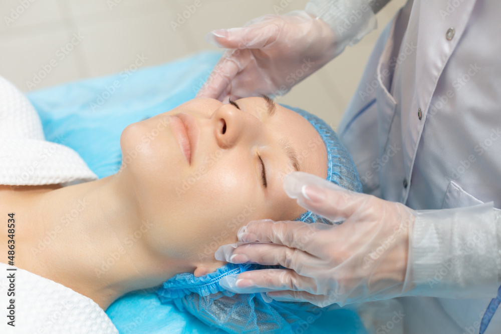 Side view of a girl relaxing on a couch during a facial massage in a beauty salon. Moisturizing and rejuvenation of the facial skin Side view of a girl relaxing on a couch during a facial massage in a beauty salon. Moisturizing and rejuvenation of the facial skin
