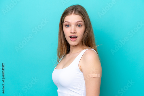Teenager Russian girl wearing a band aids isolated on blue background with surprise and shocked facial expression
