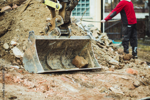 Digger bucket with rubble. House demolition. 