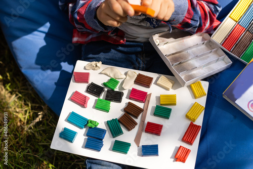 School supplies, paints and plasticine on the colored background, fresh and health fruit for a learning