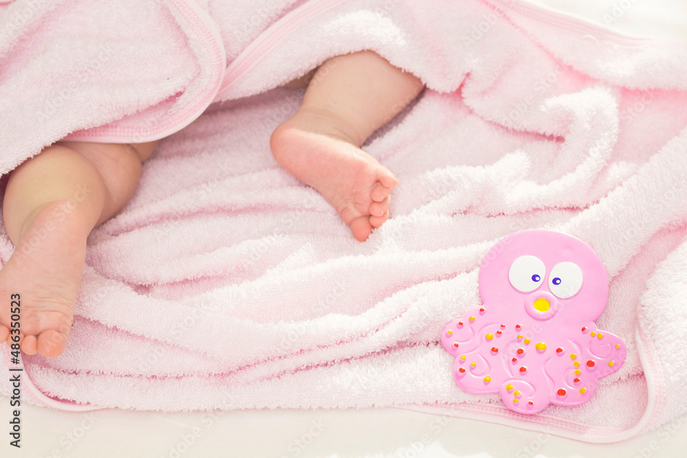 A cute baby is lying in a pink towel after a bath. Bathing babies, newborns. A cute baby is lying in a pink towel after a bath. Bathing babies, newborns.