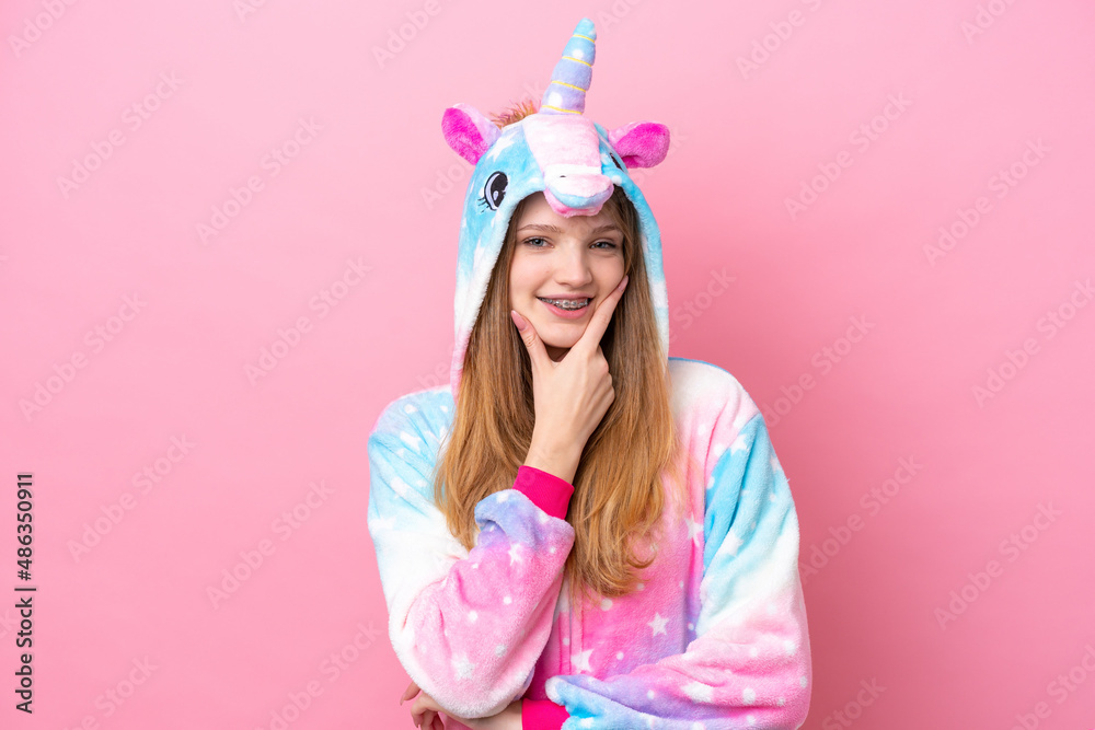 Teenager Russian girl with unicorn pajamas isolated on pink background smiling Teenager Russian girl with unicorn pajamas isolated on pink background smiling