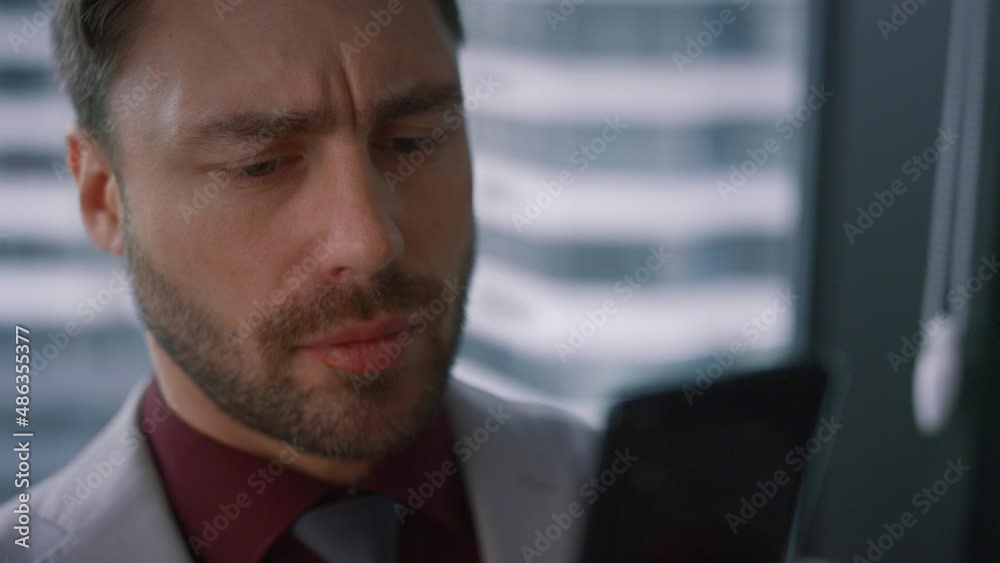 Serious executive man typing message texting sms on digital smartphone in office Serious executive man typing message texting sms on digital smartphone in office