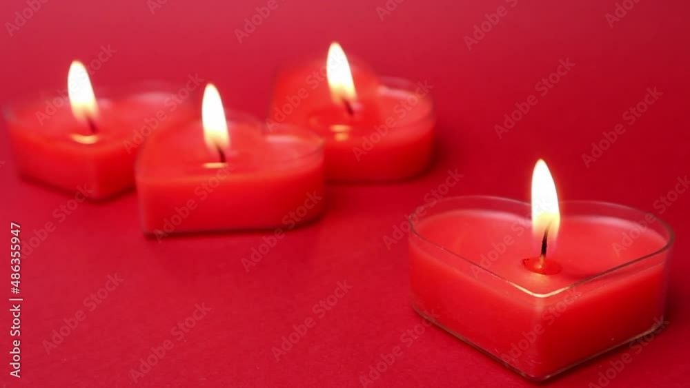 Red burning heart-shaped candles with blazing flames. Tongues of fire on a red background. Valentine's Day, passion, love, feelings, romantic mood concept. Monochrome wallpaper. Decor for February 14. Red burning heart-shaped candles with blazing flames. Tongues of fire on a red background. Valentine's Day, passion, love, feelings, romantic mood concept. Monochrome wallpaper. Decor for February 14.