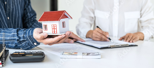 Real estate broker agent consult to customer to decision making sign insurance form and sending house model to client after approve, home model mortgage loan offer for and house insurance