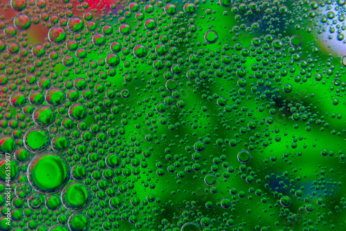 Bubbles in oil in water on green colour abstract background