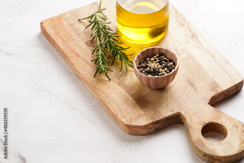 Cooking ingredients  olive oil  fresh rosemary  milk  pepper on wooden board