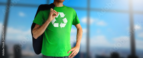 Environmental business man opens his shirt to show recycle mark in modern office. Protect and save Earth Planet Blurred skye. Concept of environmental.
