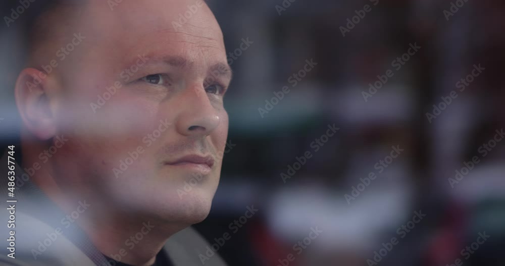 The man is watching closely what is happening outside the window The man is watching closely what is happening outside the window