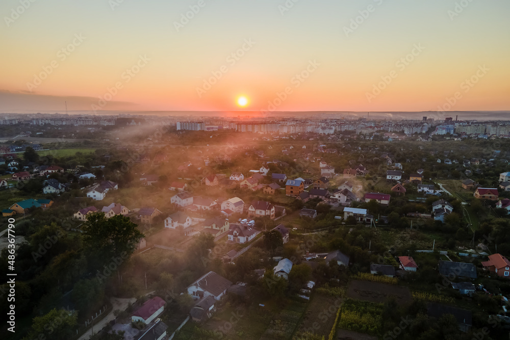 Aerial view of residential houses in suburban rural area at sunset