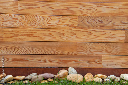 Western red cedar exterior cladding with decorative stones, wood pattern natural background. photo