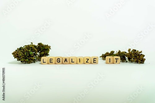 The word LEGALIZE IT, spelled with wooden letters wooden cube on a plain white background, concept image on theme drug legalization photo
