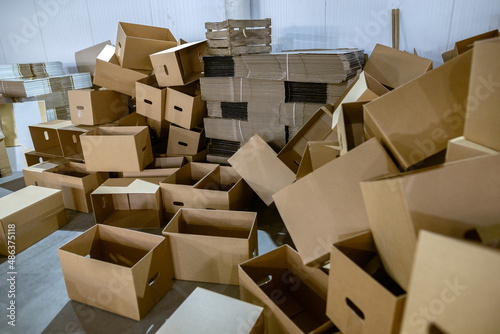 Assembled and disassembled folding cardboard boxes of perforated sheets of corrugated cardboard. Packaging of finished products in industrial production.