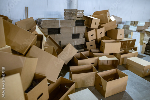 Assembled and disassembled folding cardboard boxes of perforated sheets of corrugated cardboard. Packaging of finished products in industrial production. © Sodel Vladyslav