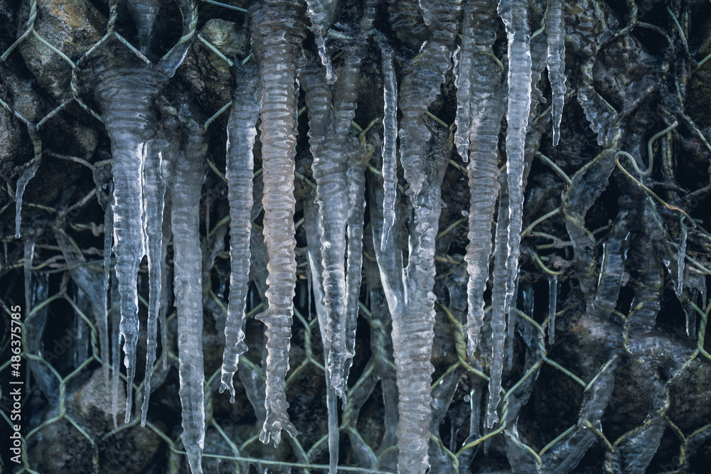 Many icicles are formed on a rock wall. High quality photo Many icicles are formed on a rock wall. High quality photo