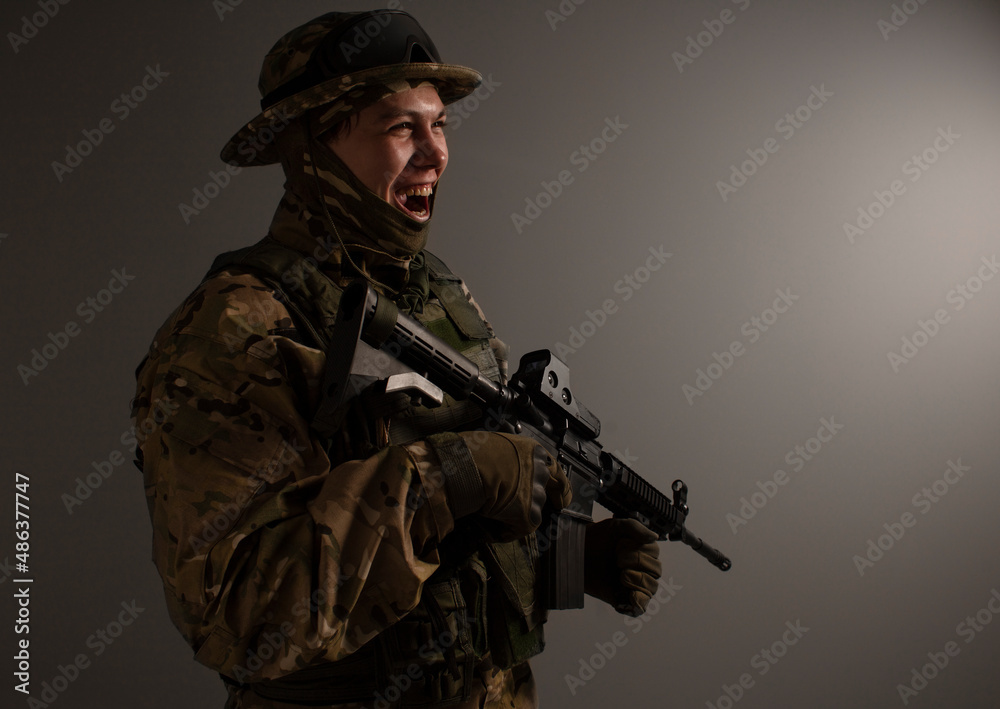 A close-up shot of a military man in a uniform in a hat with goggles giving orders in front of a building. Soldier in the panic. Military Conflict Actions. Man In camouflage. Soldier in the panic.