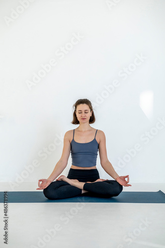 Portrait of happy young caucasian woman exercising yoga. Healthy lifestyle. Woman meditating at home.
