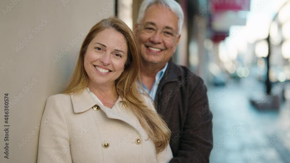 Middle age couple couple smiling confident hugging each other at street Middle age couple couple smiling confident hugging each other at street