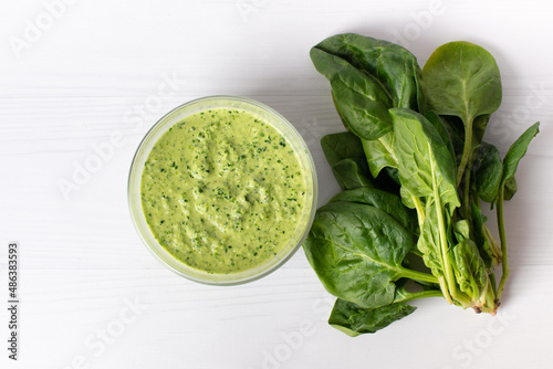 Delicious spinach sauce on a white table, flat lay. Place for text