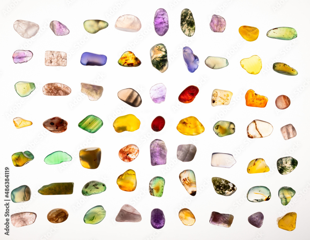 Assortment of polished semi-precious small transparent gemstones on white background	