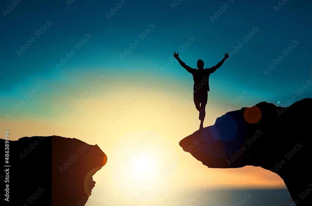 A silhouette man jump between 2021 and 2022 years with sunset background, Success new year concept.