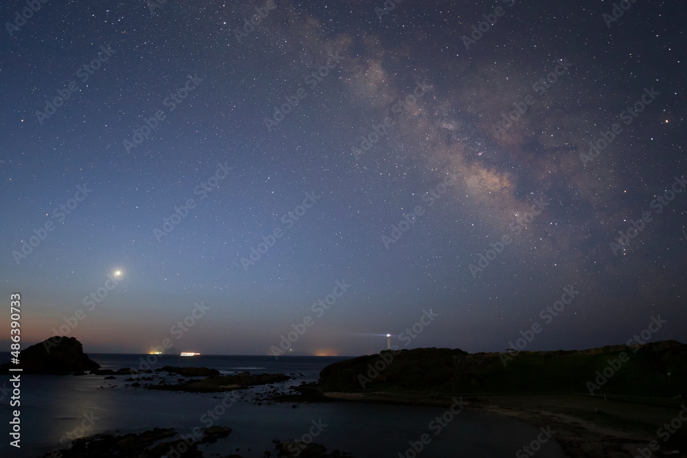 伊豆半島にある灯台の上に輝く天の川と明けの明星