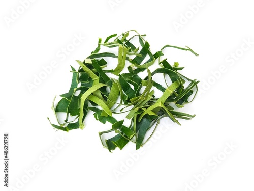 Fresh organic kaffir lime leaves, no chemicals, cut into pieces as a cooking ingredient.  Green leaves, placed on a white background.