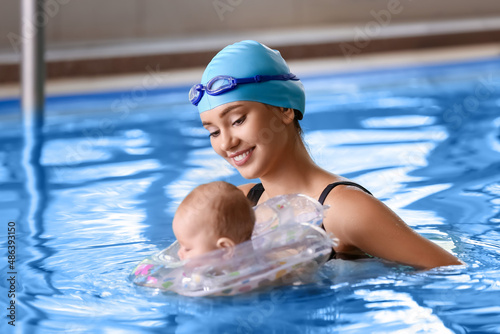 Young woman and her adorable baby with inflatable ring in swimming pool © Pixel-Shot