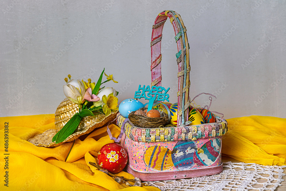 Fototapeta premium Easter basket with Easter decorations on a table and texture background