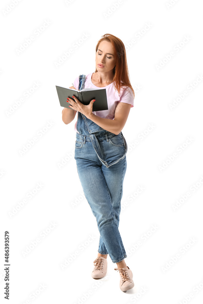 Young redhead woman writing in notebook on white background Young redhead woman writing in notebook on white background