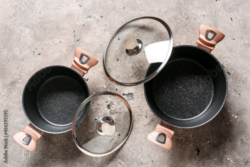 Fotografie Cooking pots and lids on grunge background