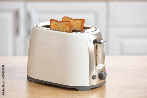 White toaster with bread slices on counter in modern kitchen