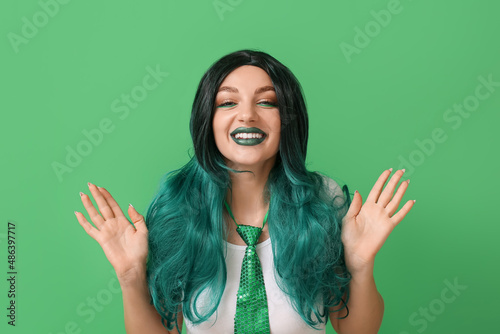 Young woman in wig on green...