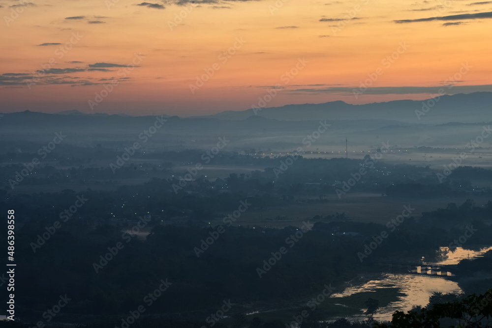Urban city view (include river, bridge, hanging bridge) in a morning with mountain range silhouette at sunrise time