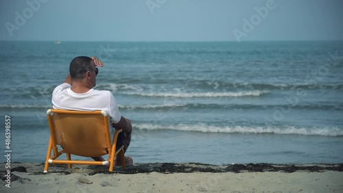Life gaurd sitting in chair looking into the distance photo