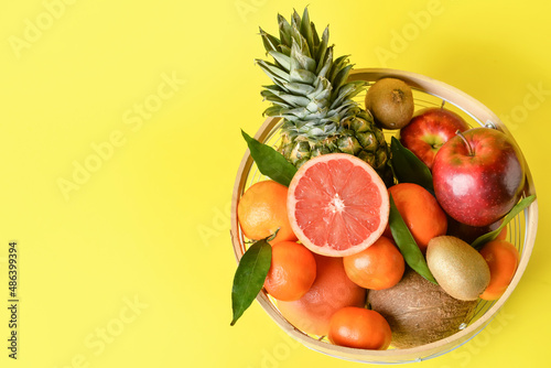 Fototapeta Naklejka Na Ścianę i Meble -  Basket with fresh juicy fruits on color background