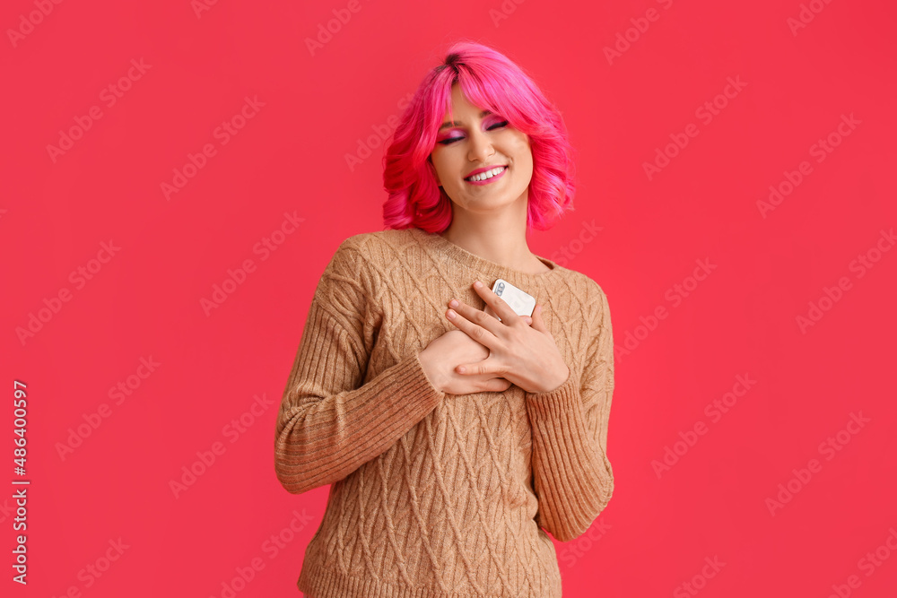 Happy young woman with mobile phone on red background Happy young woman with mobile phone on red background