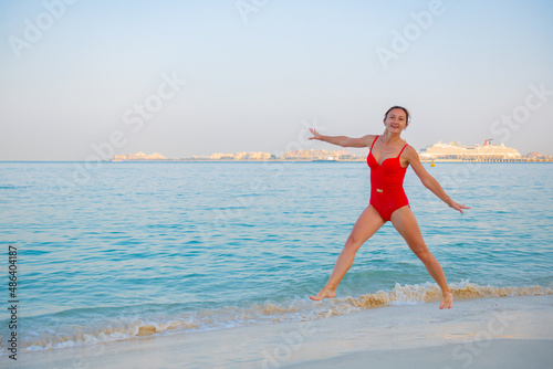 beautiful young woman in swimsuit jumping on the beach