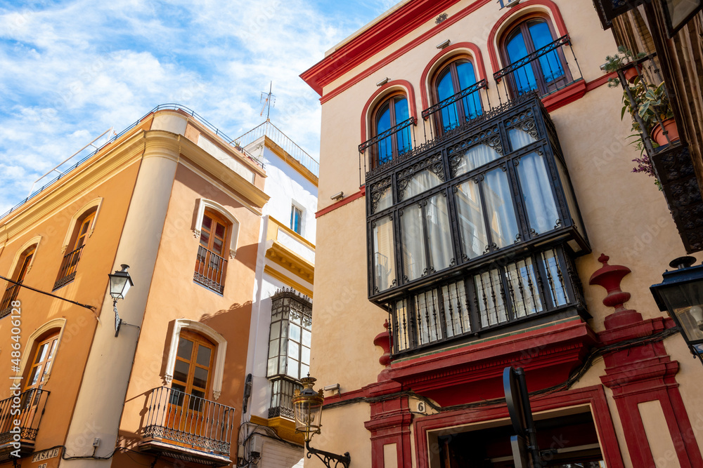 Obraz premium Typical Andalusian color and architecture on residential buildings in the Barrio Santa Cruz district of Seville, Spain.