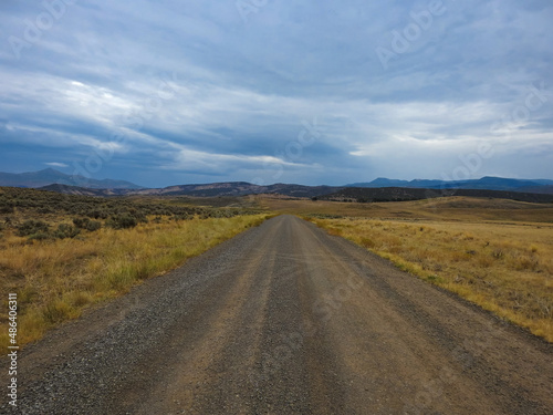 A Countryside Gravel Road Leading Down into Mountains on the Horizon