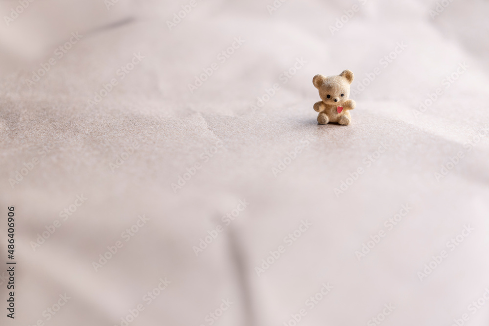 Obraz premium osito de juguete vintage con corazón en el pecho, con fondo café y espacio para poner texto del día de san Valentín y 14 de febrero