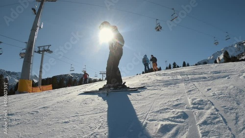 Young athletic ski woman standing under chair ski lift on high altitude mountain slope photo