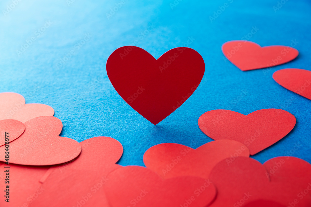 Paper cut red hearts shape on blue textured background with copy space. Concept image. Valentine's day, mother's day, birthday greeting cards, invitation, celebration