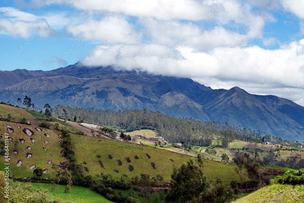 Farms on the slopes around Taxopamba Waterfall outside of Otavalo, Ecuador, with the mountains rising in the background