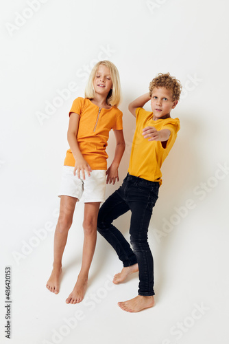 cute boy and girl in casual clothes studio full length posing