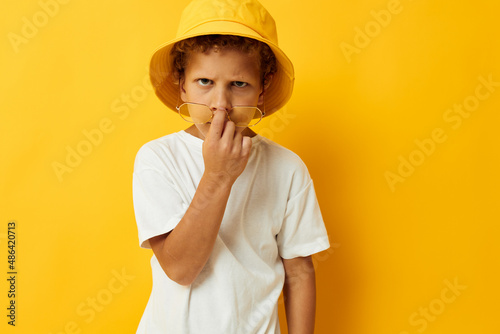 boy in white t-shirt yellow hat posing emotions