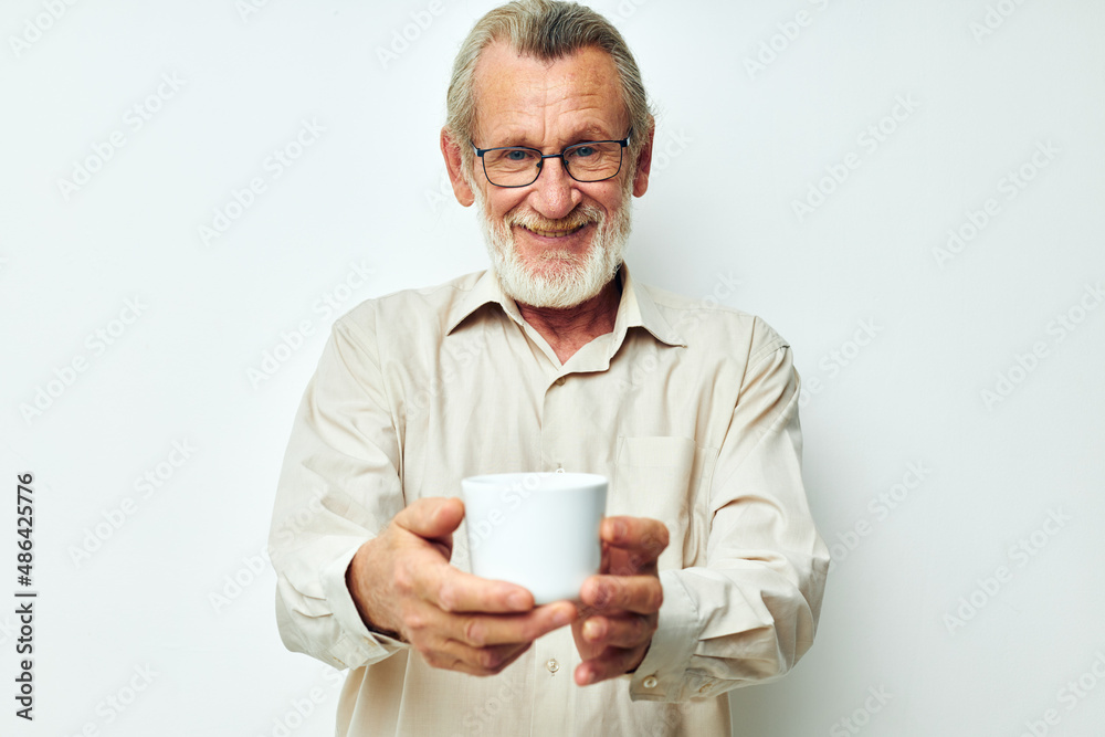old man with glasses shows a mug on a white background old man with glasses shows a mug on a white background